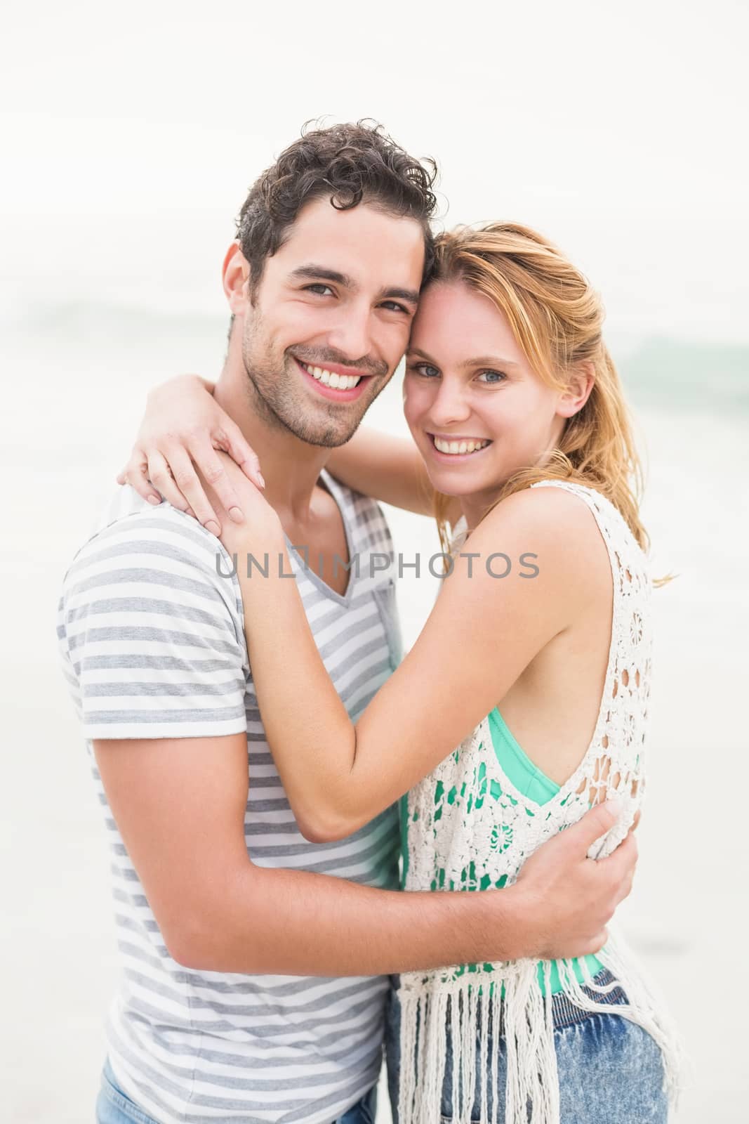 Young couple embracing each other on the beach by Wavebreakmedia