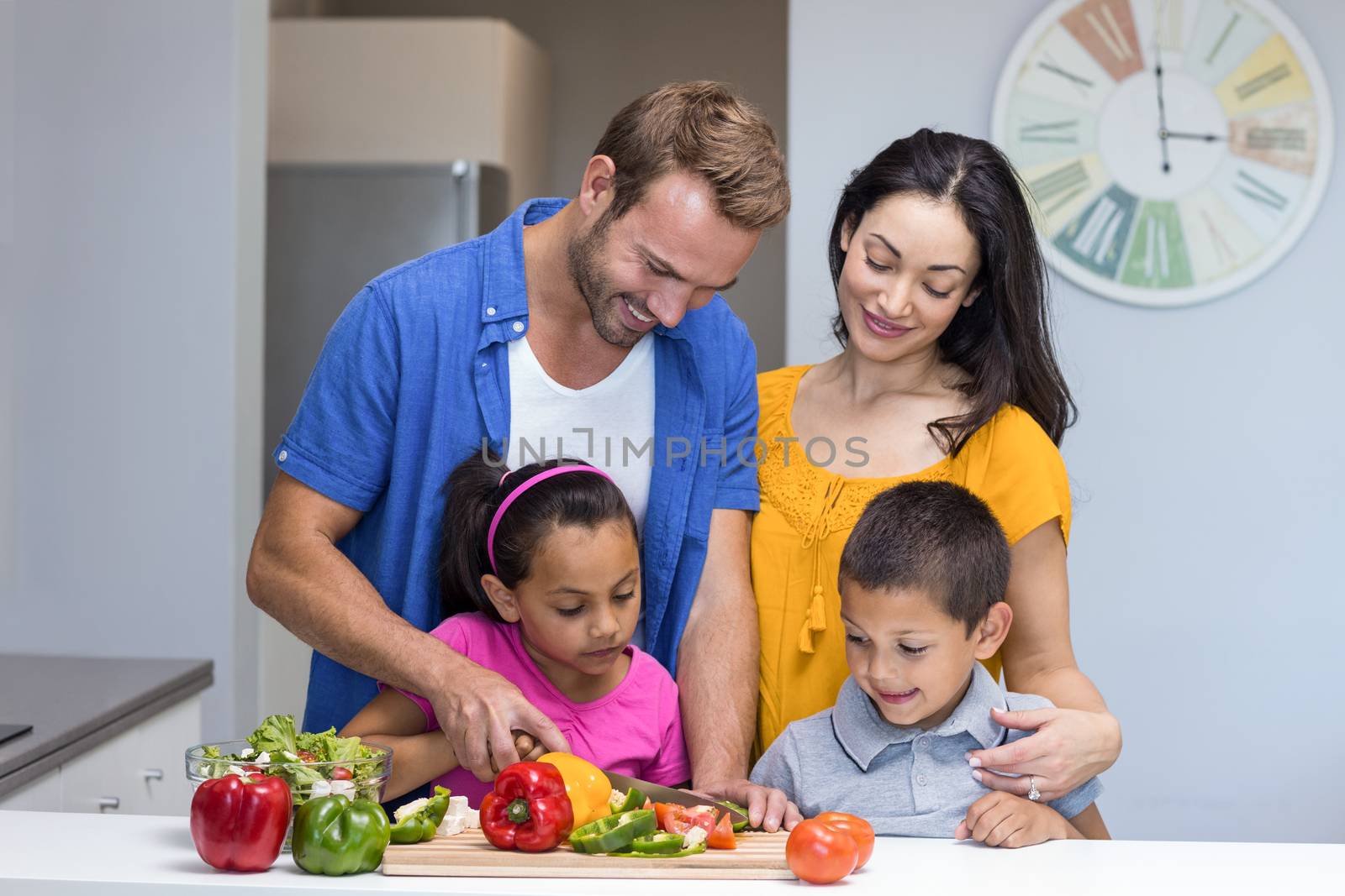 Happy family in the kitchen chopping vegetables at home