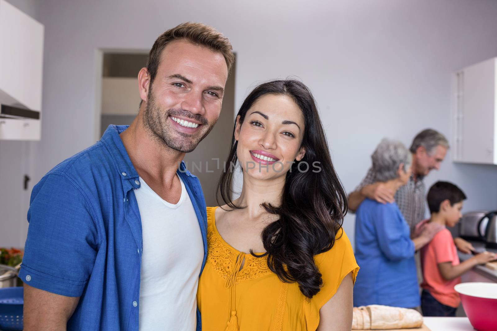 Portrait of happy young man and young woman standing in kitchen
