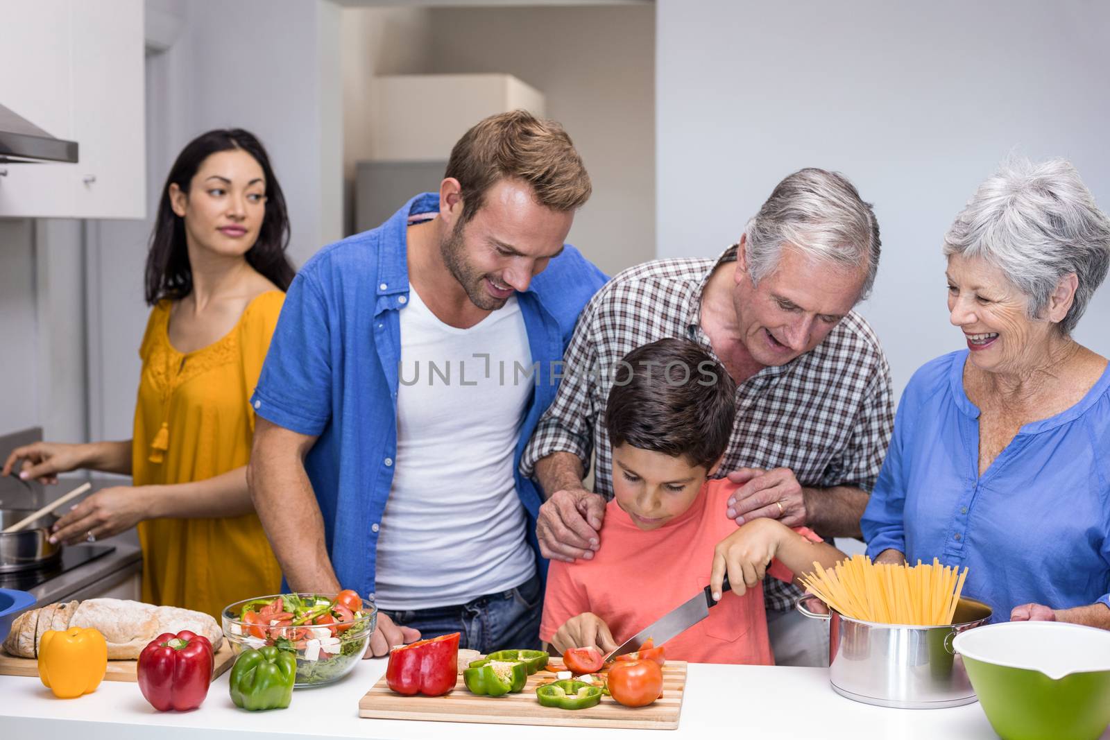 Happy family in the kitchen chopping vegetables at home