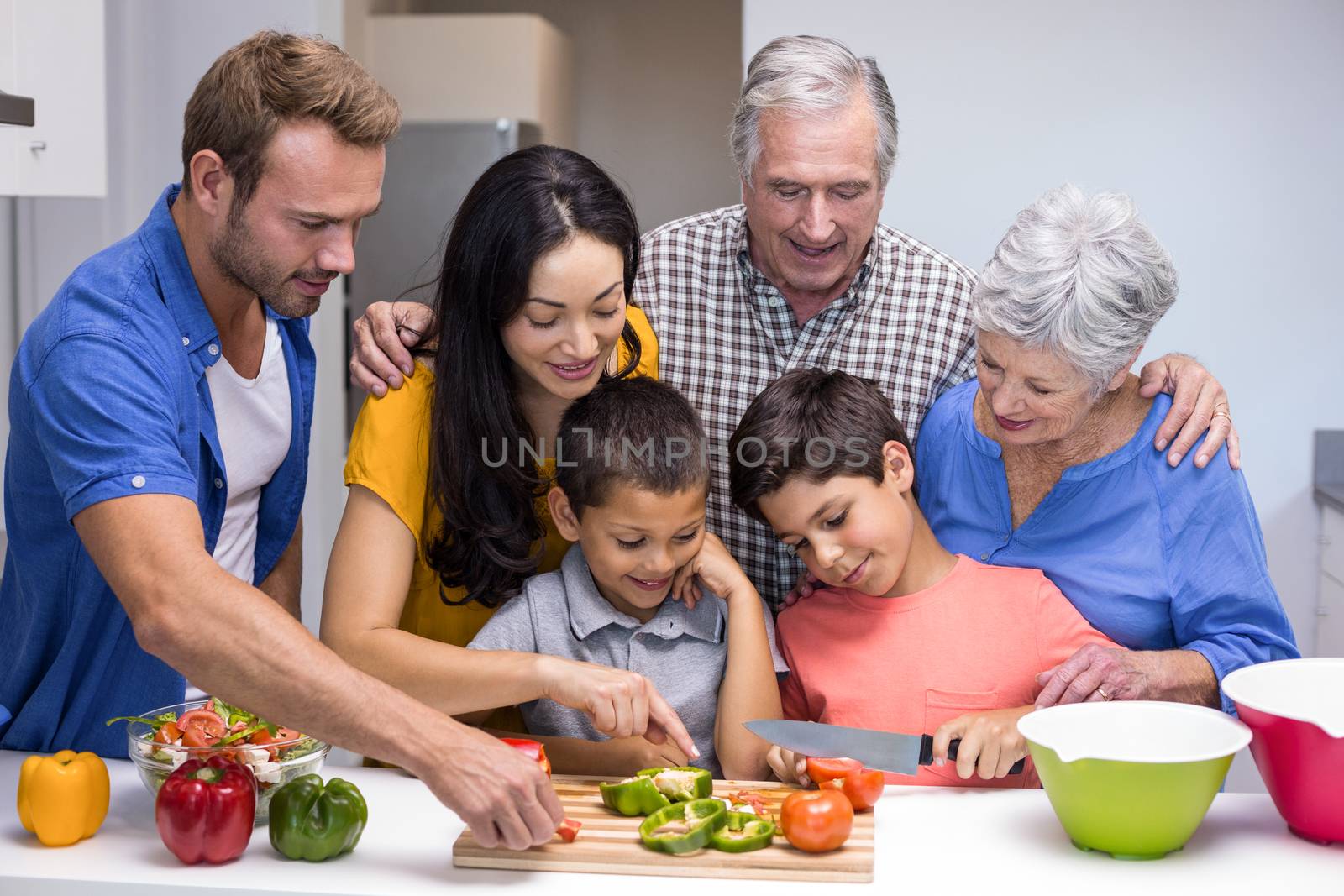 Happy family in the kitchen chopping vegetables at home