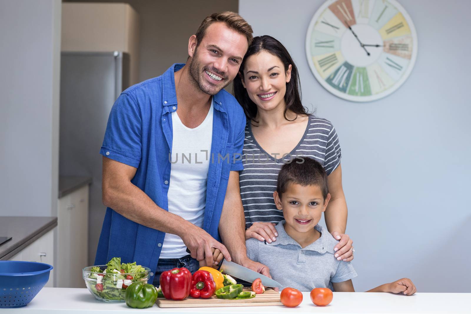 Happy family in the kitchen chopping vegetables at home