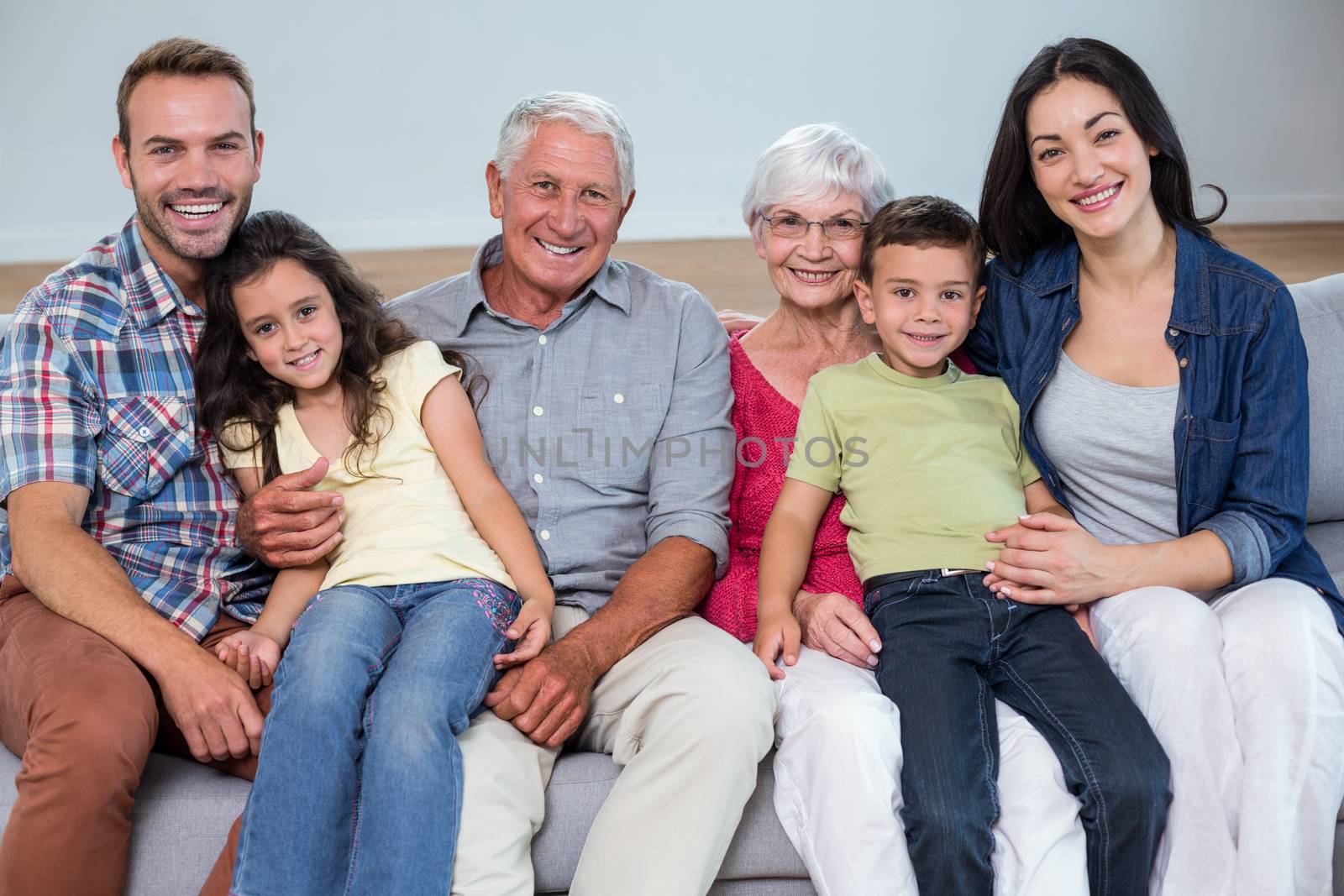 Portrait of family sitting on sofa and smiling in living room