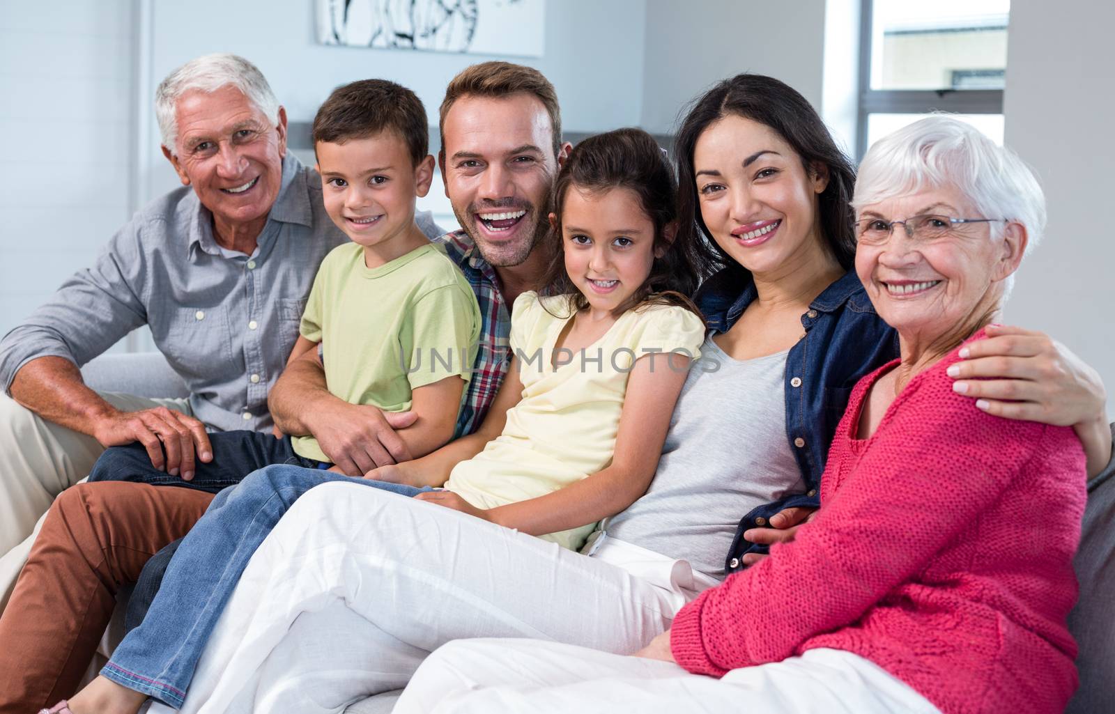 Portrait of family sitting on sofa and smiling in living room