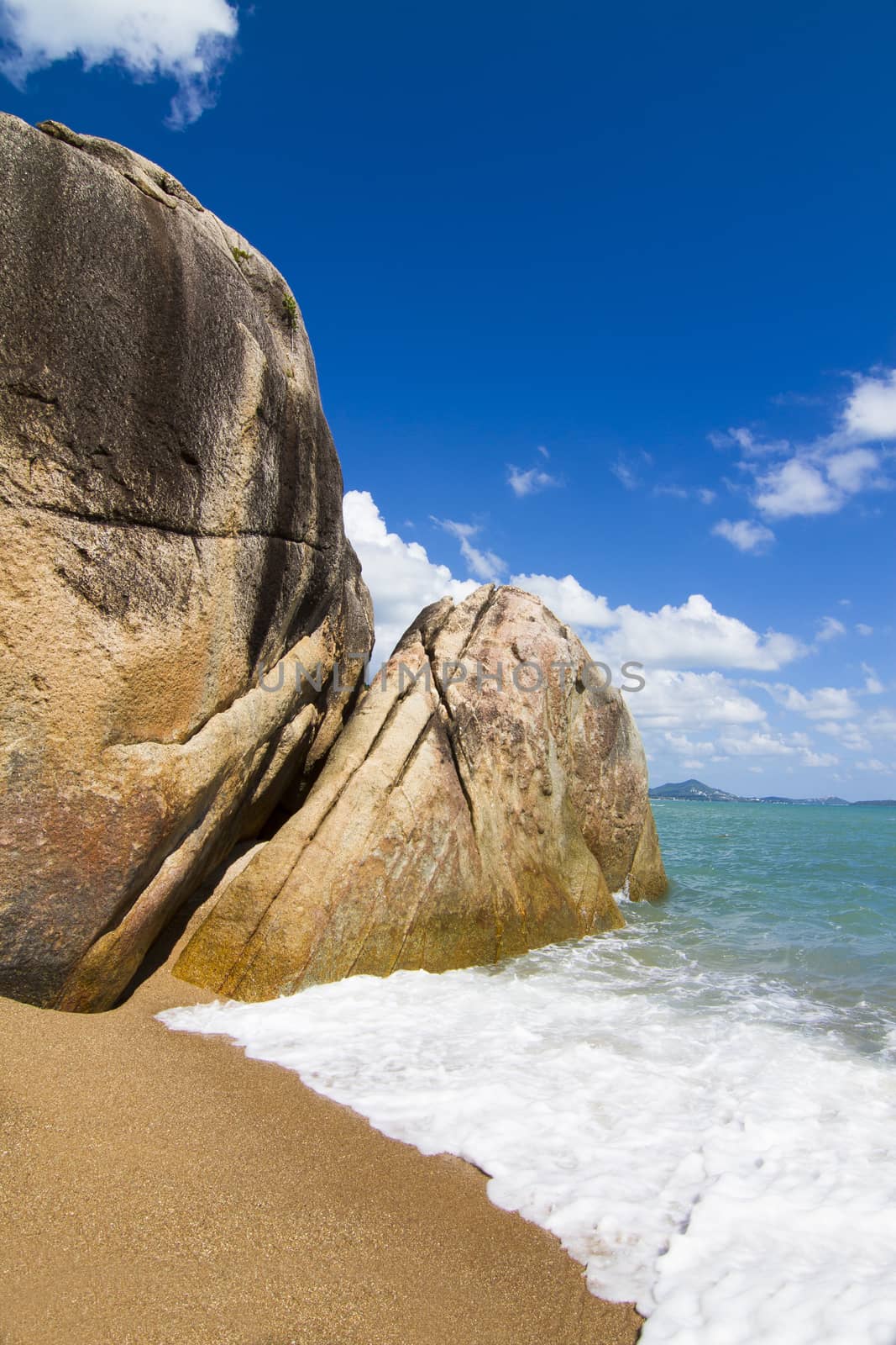 There are beautiful views of the beach, the waves and the rocks.