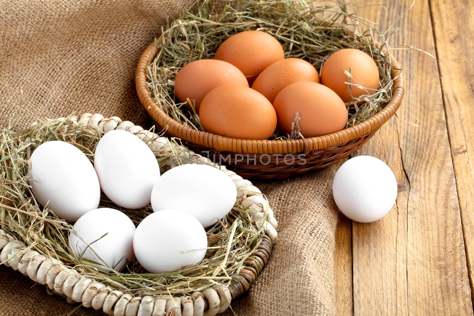 Eggs in basket on wooden background by motorolka