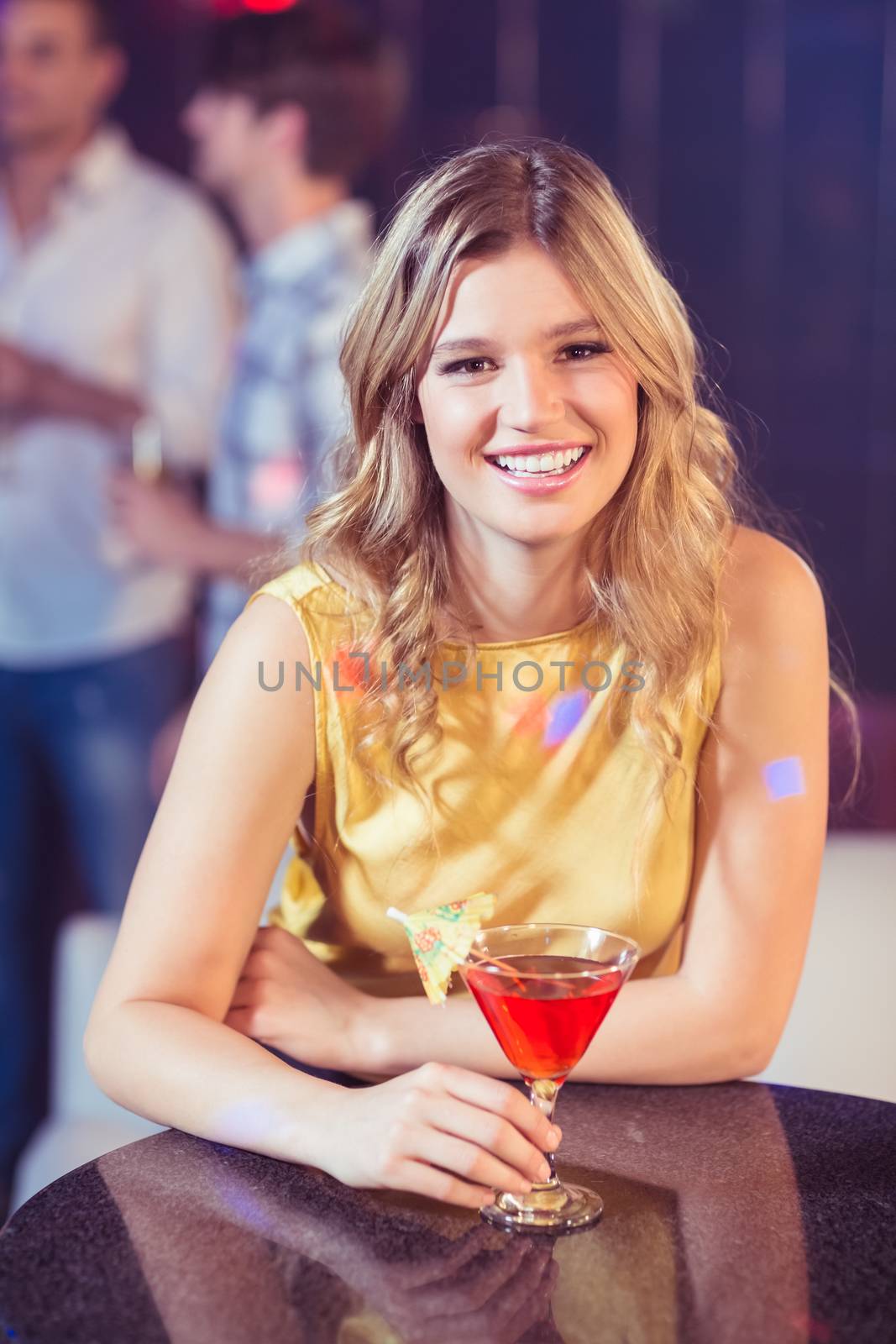 Pretty woman with a cocktail in a club