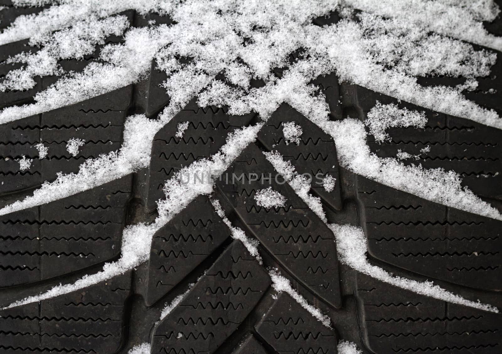 Close up of an old tire half covered in snow