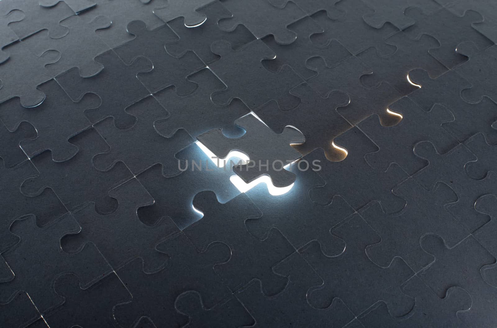 Grey puzzle background with flying piece, close up view