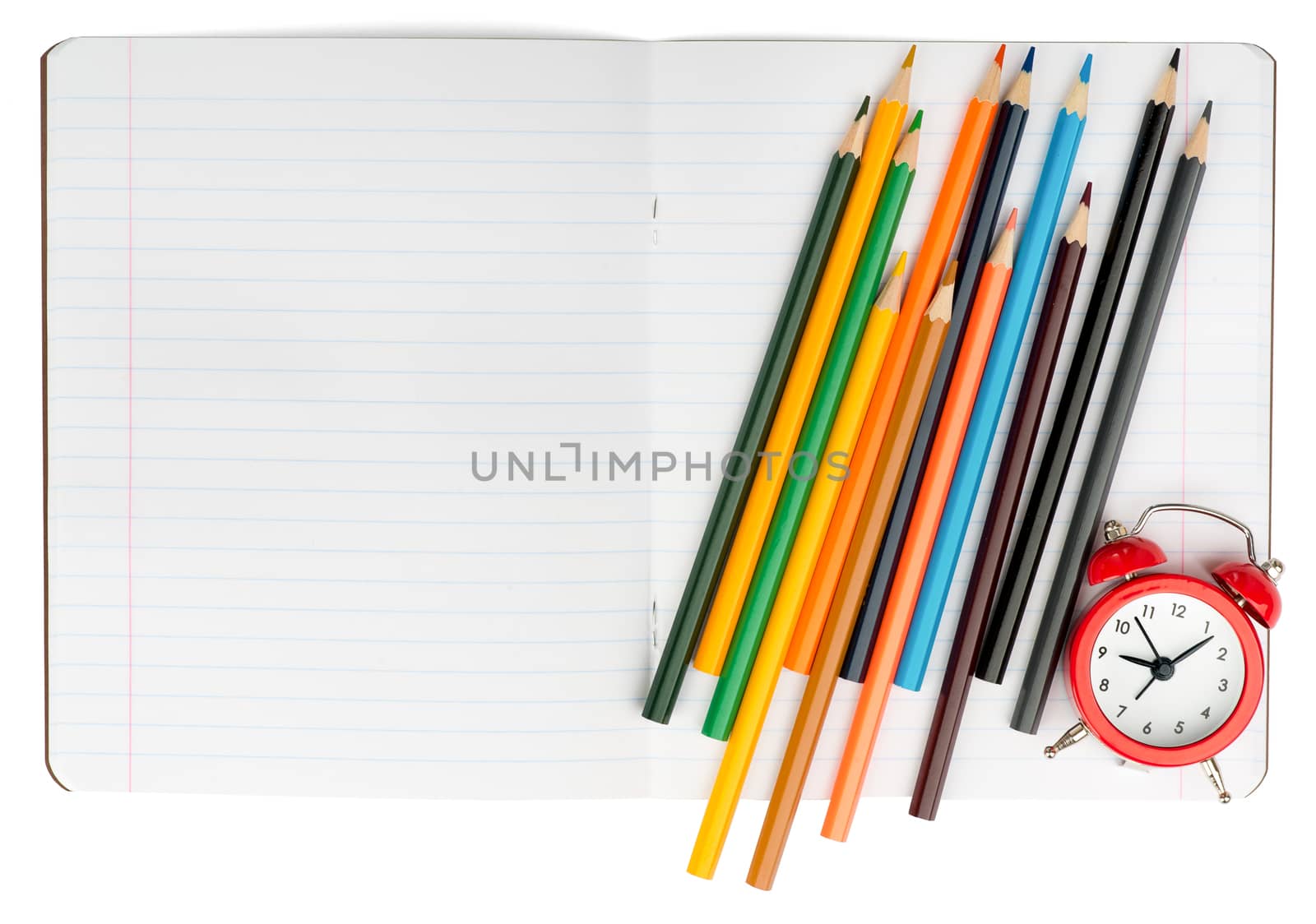 Open notebook with crayons and alarm clock on isolated white background, closeup
