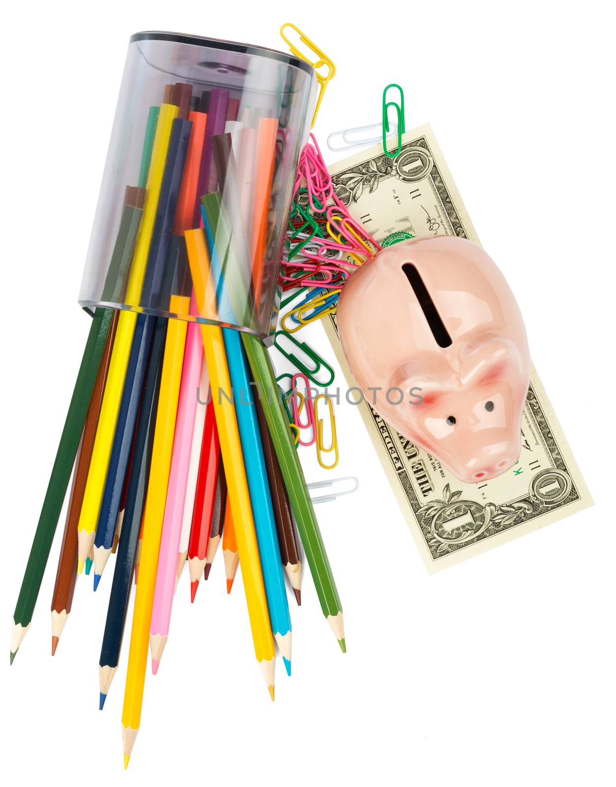 Piggy bank with crayons and paper clips on white background