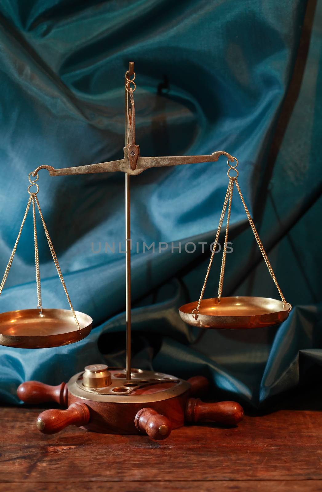 Closeup of old brass weight scales on green cloth background