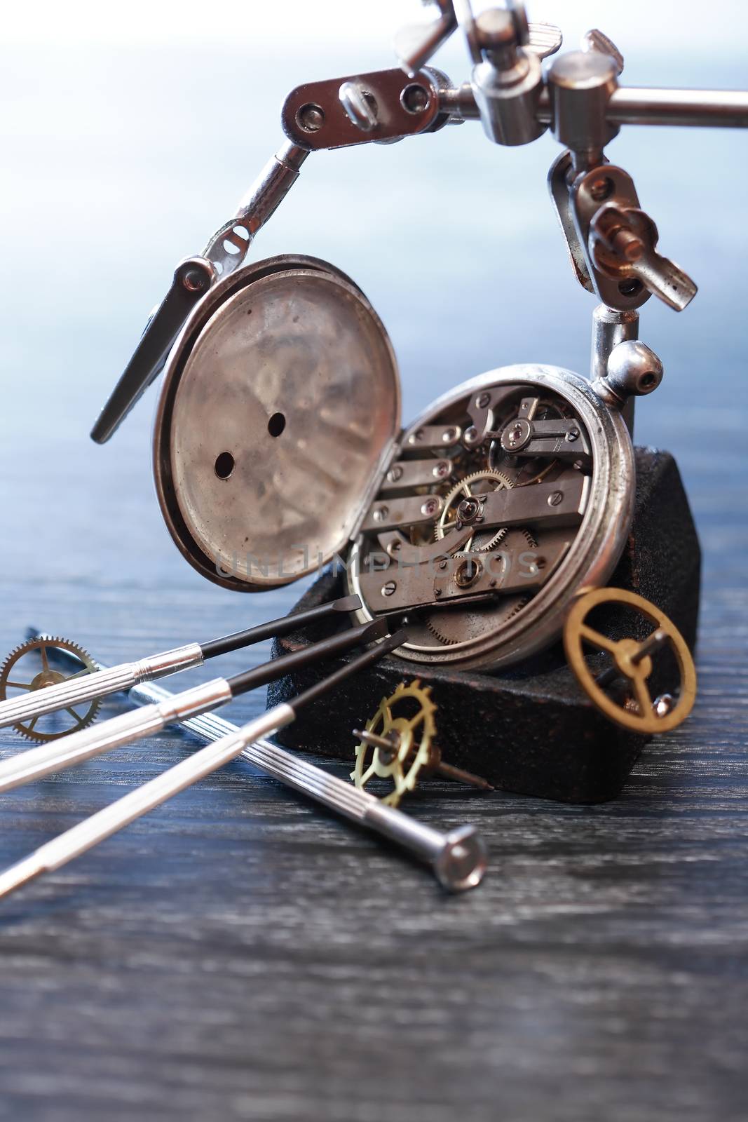 Hour workshop. Vintage still life with ancient silver pocket watch