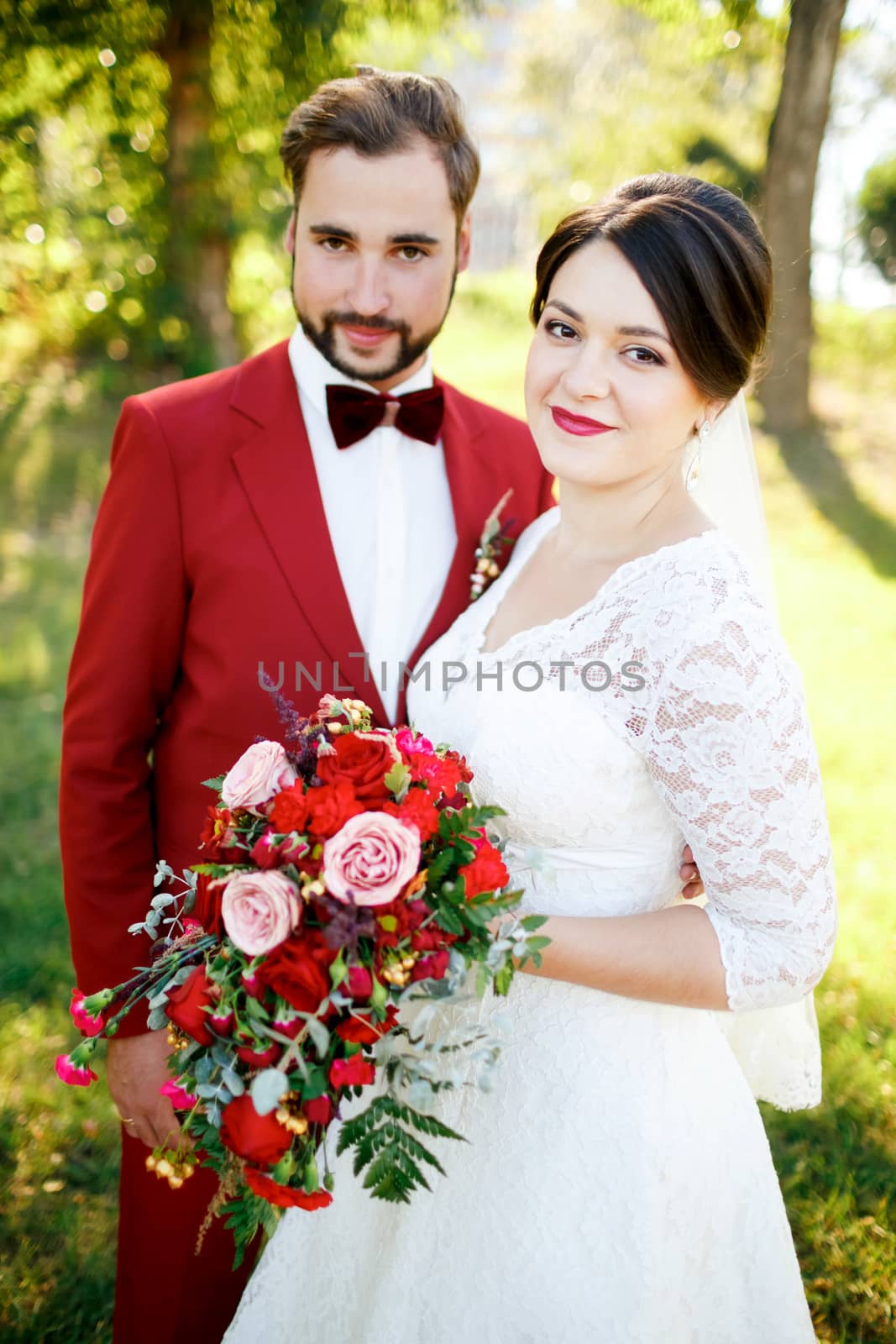 Portrait of the newlyweds couple outdoors, summer, vertical. Marsala decoration style.