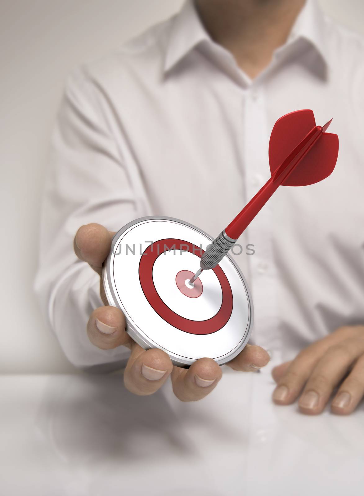 One target and a dart in man hand, symbol of accomplishment or career. White shirt