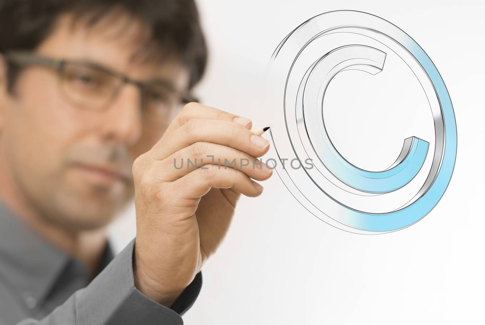 Creative man drawing copyright symbol on a transparent wall. Engineering background concept over white.