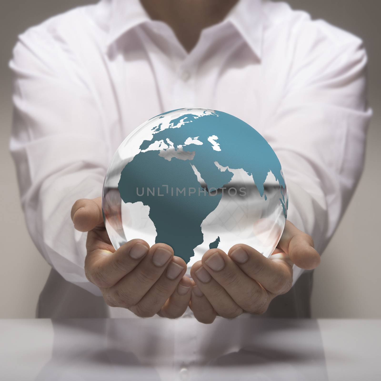 Image of a man in white shirt holding in its hands a glass earth. Earth concept for care and environmental protection or global business.