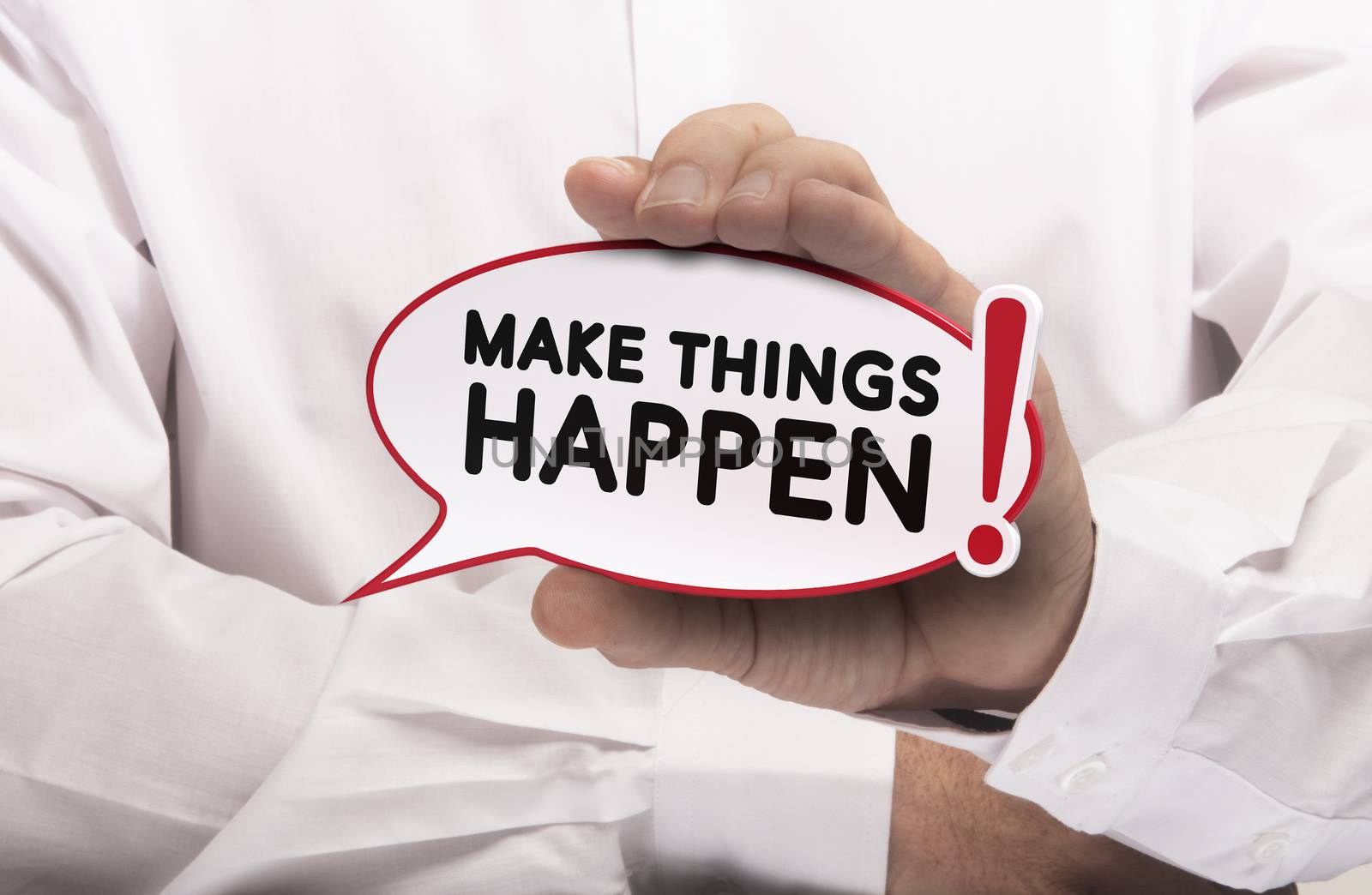 Image of a man hand holding speech balloon with the text make things happen, white shirt. Concept for motivation and goal achievement.