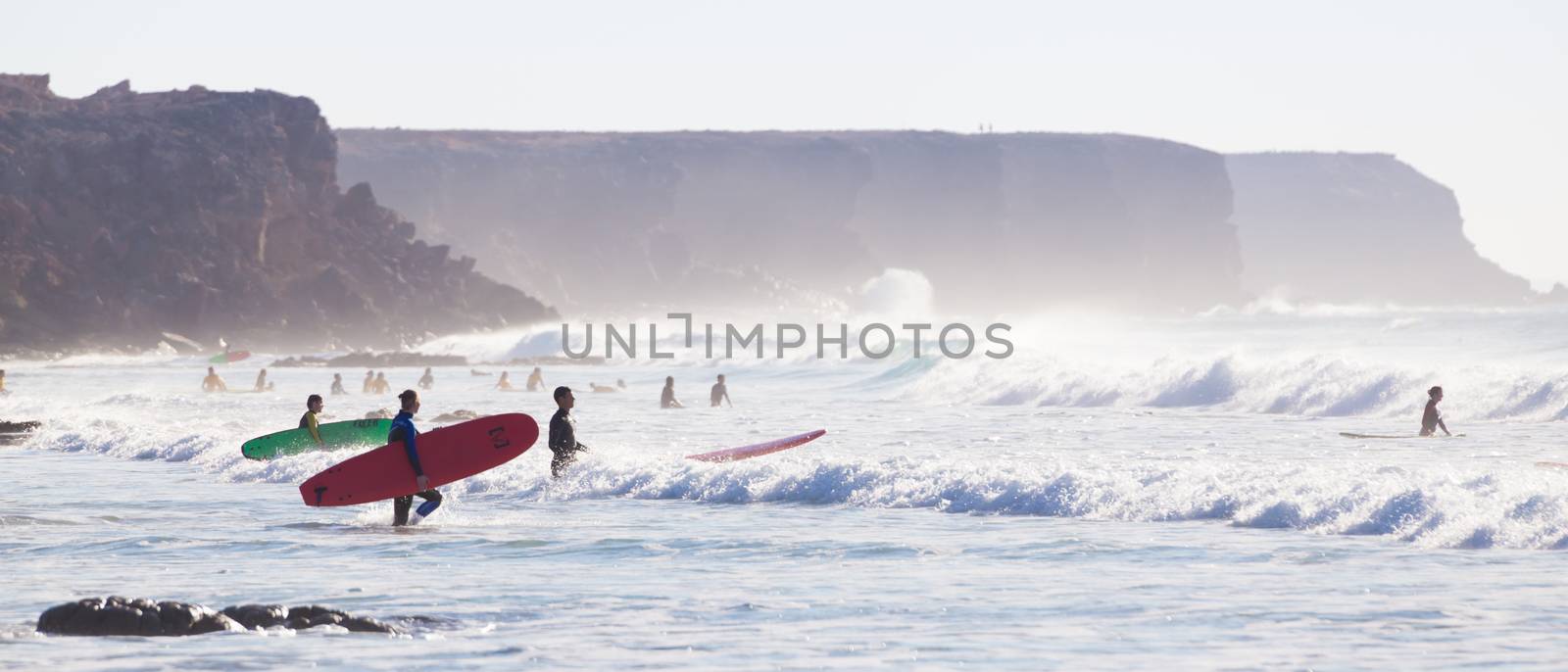 EL Cotillo, Spain - Dec 17, 2015:  Active sporty people having fun learning to surf on El Cotillo beach, famous surfing destination on Fuerteventura, Canary Islands, Spain on December 17, 2015. 