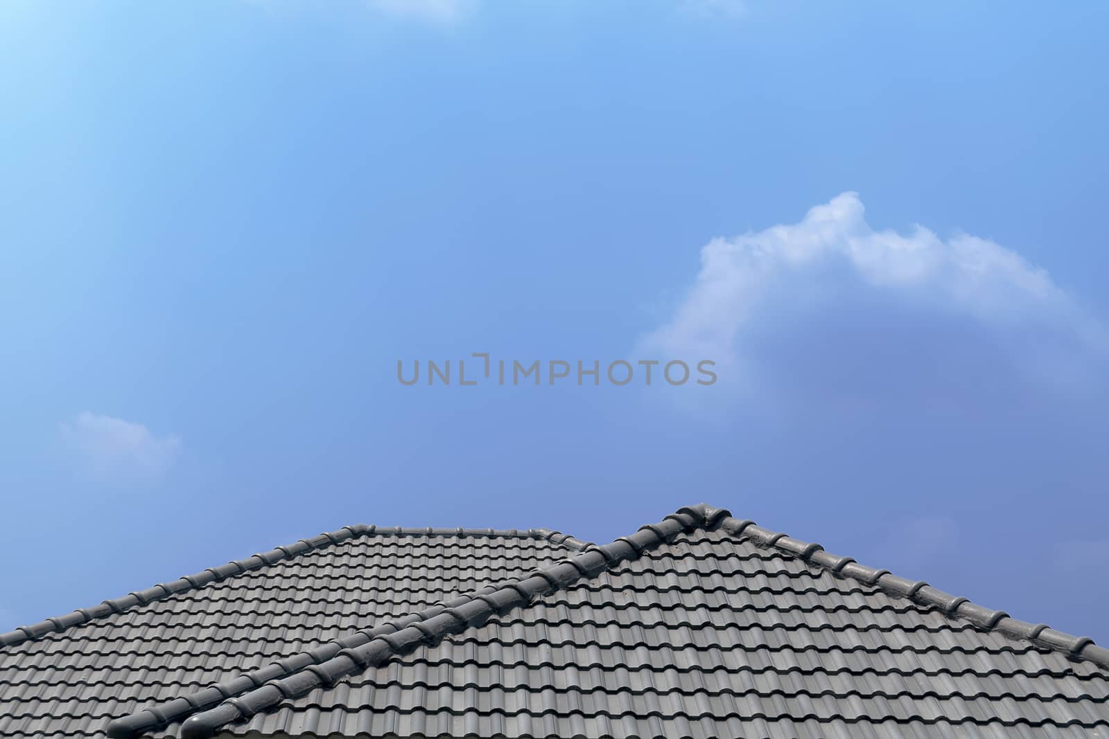 Roof house with tiled roof on blue sky by suthee