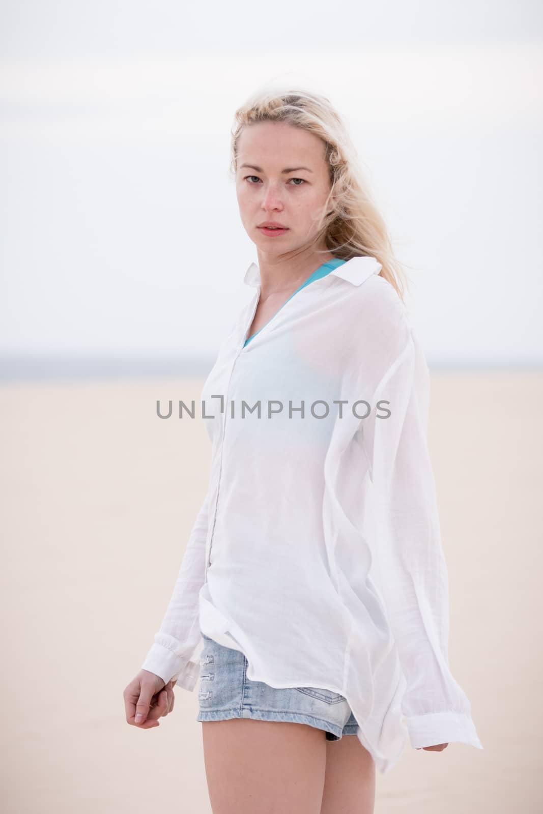 Beautiful sensual woman alone at beach. Melancholic vintage mood. Summer moved on.