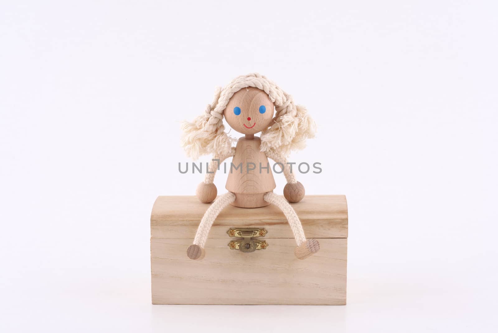 hand made wooden girl sitting on a wooden chest