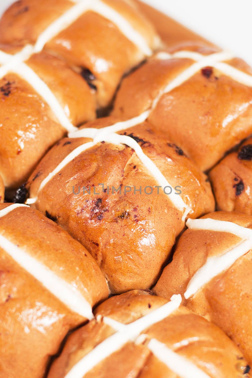 Hot cross buns on a timber board with a white background.