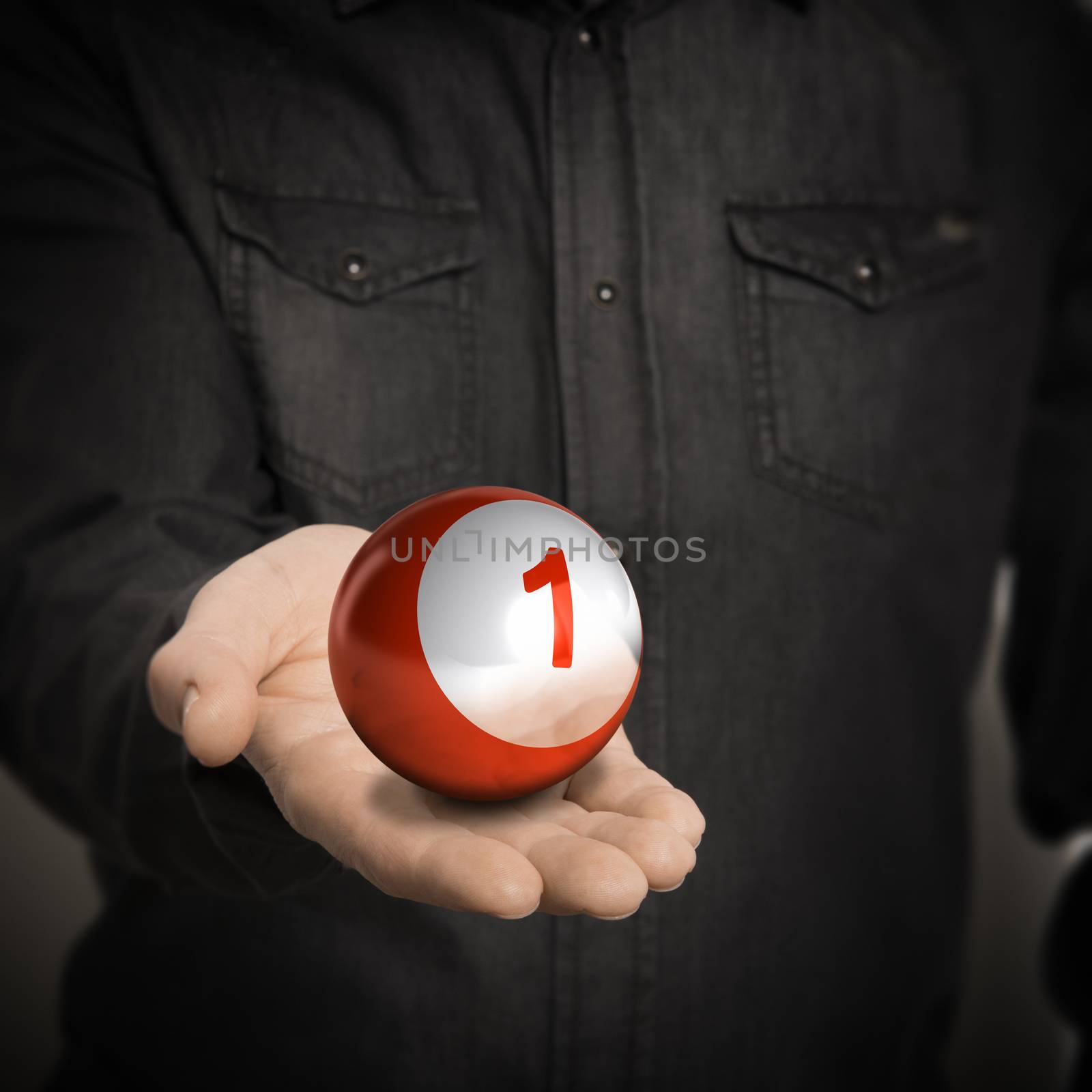 Man hand holding red ball with number one over blackbackground, concept image for illustration of leader.