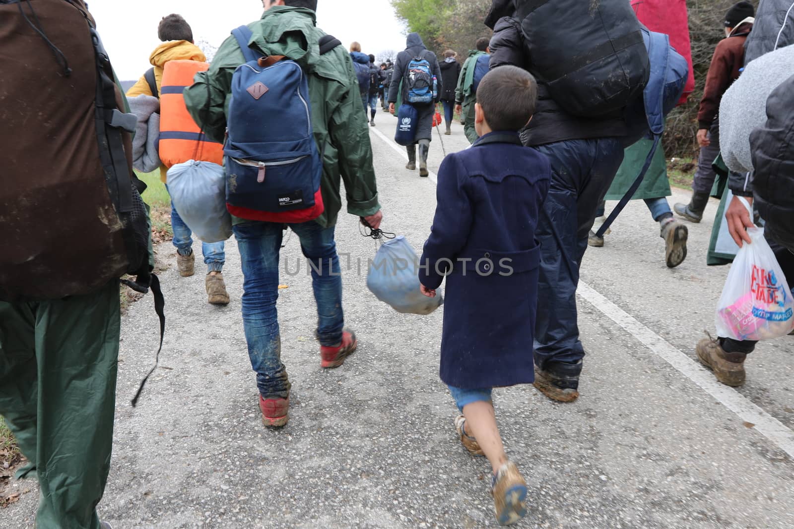 GREECE, Idomeni: Hundreds walk in the country between Greece and Macedonia as migrants and refugee cross a surging river on their way to Macedonia from a makeshift camp at the Greek-Macedonian border, near the Greek village of Idomeni on March 14, 2016, where thousands of them are stranded by the Balkan border blockade. More than 14,000 people are stuck on the Greek side of the border in an overcrowded camp at Idomeni after the main migrant route to western Europe through the Balkans was effectively shut down last week.