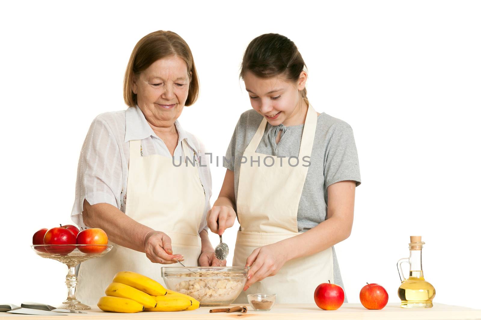 the grandmother and the granddaughter fill ingredients in a bowl by sveter