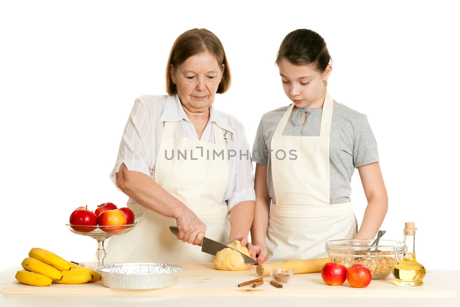 the grandmother and the granddaughter cut dough by sveter