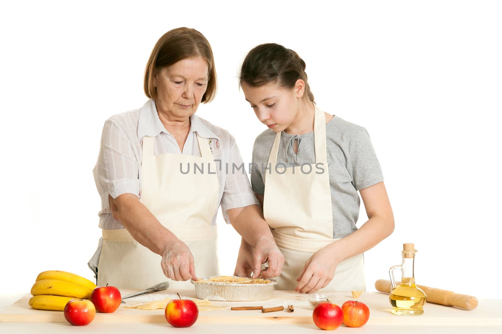 the grandmother and the granddaughter stack dough strips by sveter