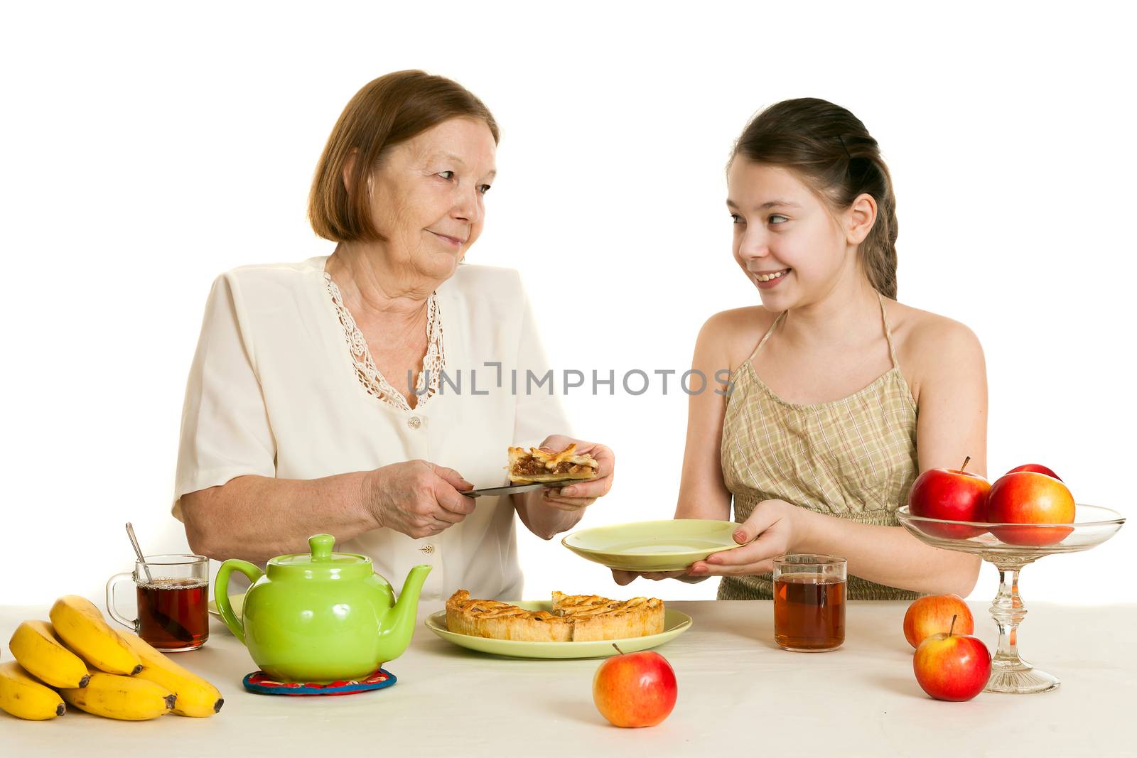 the grandmother treats the granddaughter with pie at a table