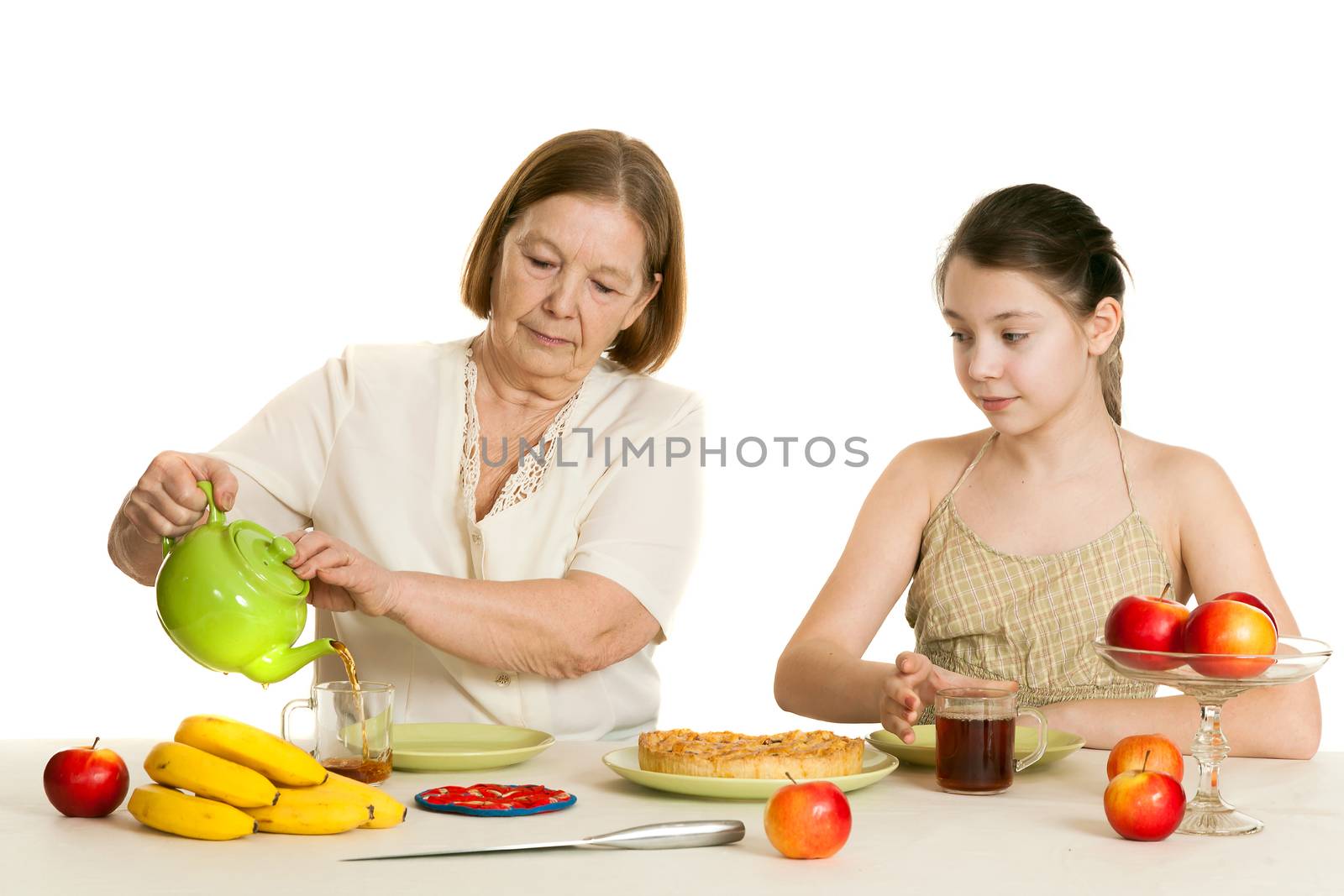 the grandmother treats the granddaughter with pie at a table