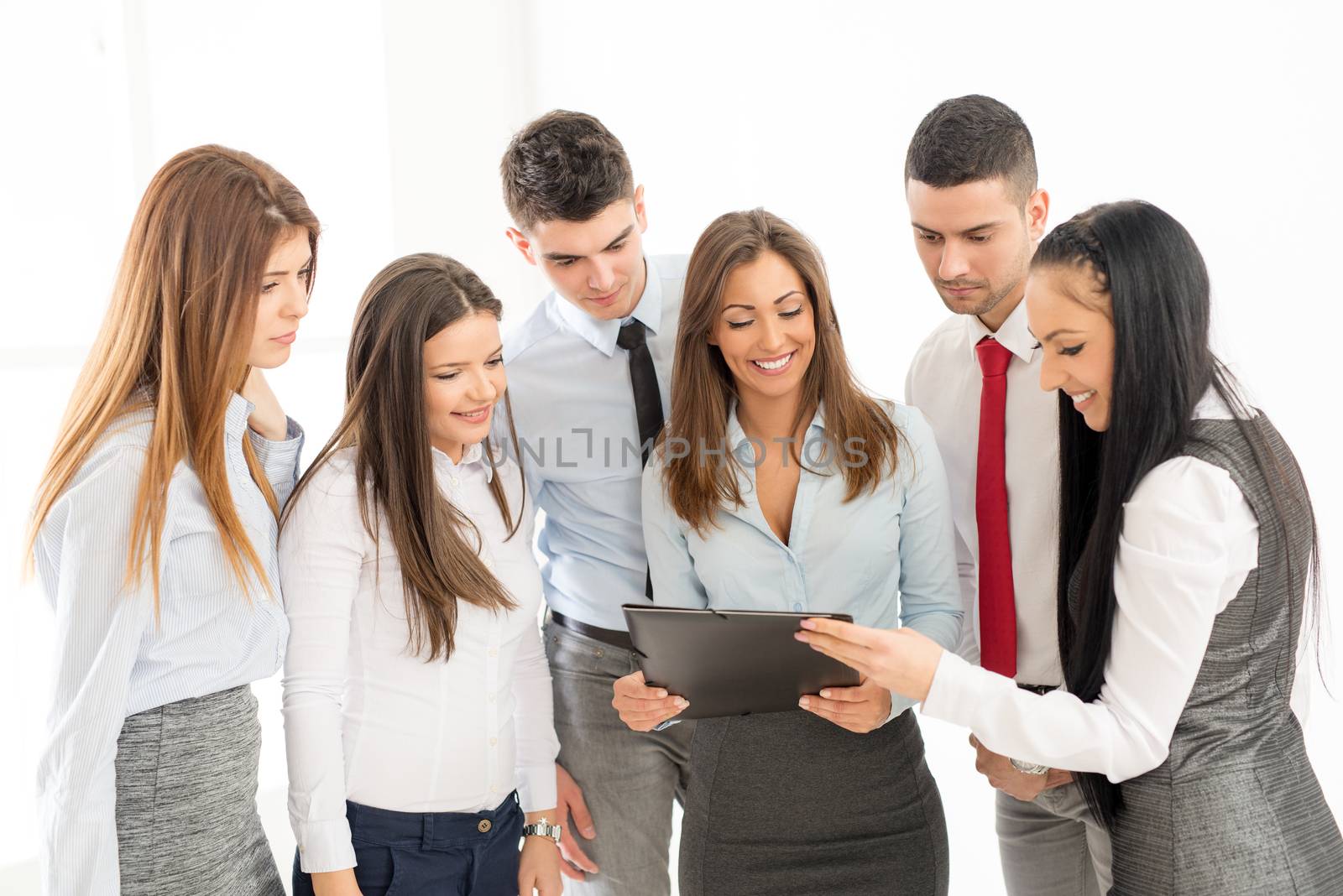 Smiling group of a young businesspeople discussing. 