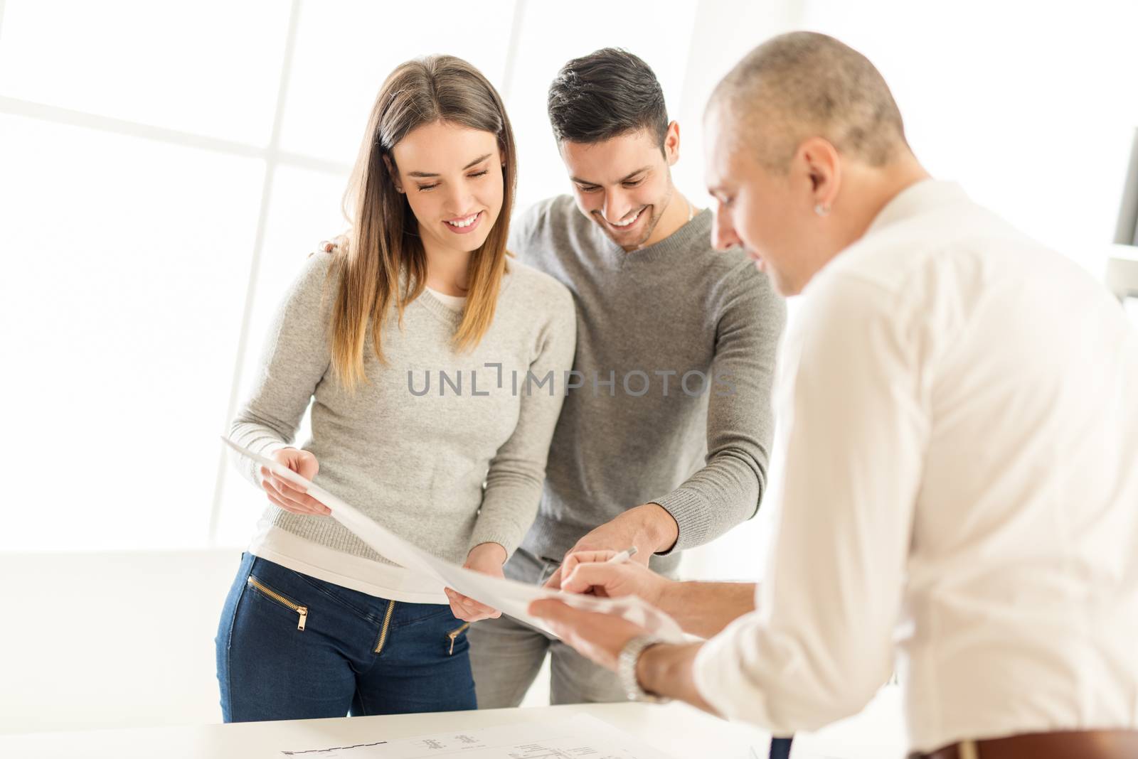 Young Couple consult with real estate agent about buying new house.