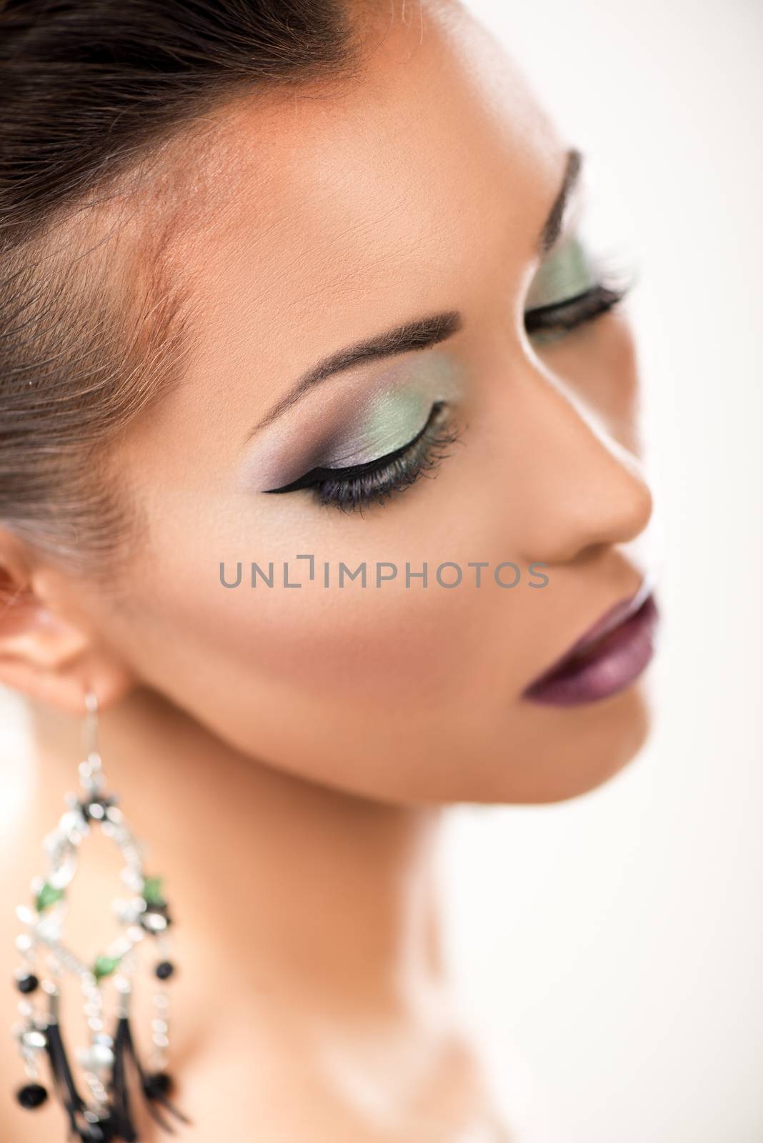 Portrait of a attractive young woman with nice make up posing in a studio. Close-up.
