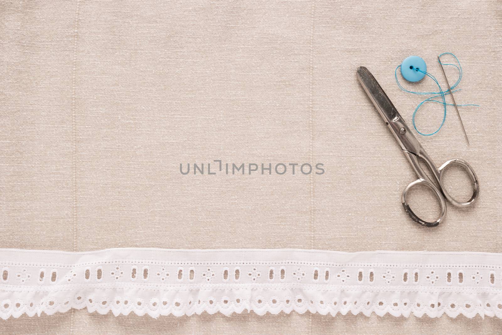 Rustic fabric for sewing, lace and accessories for needlework on old wooden background. Top view with copy space.