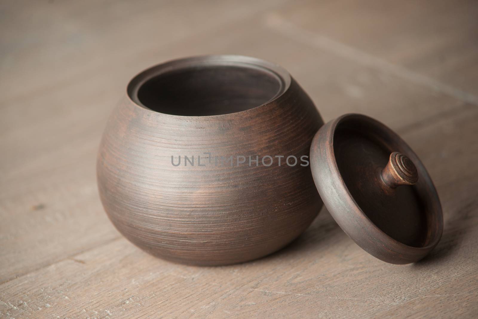 Traditional handcrafted brown pot with a cap