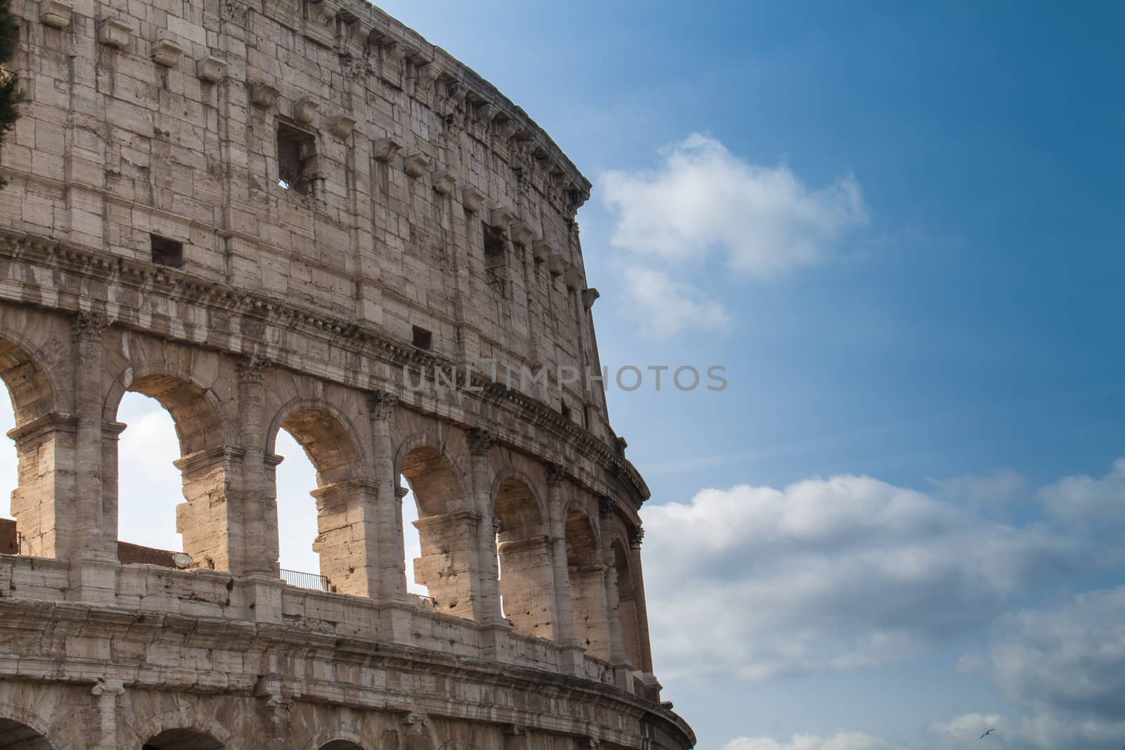 Colosseum as an iconic symbol of Imperial Rome. Blue sky with clouds.