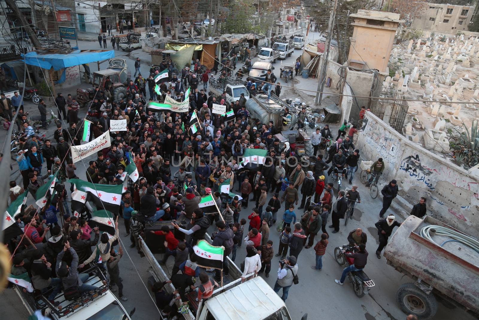 SYRIA, Saqba: Hundreds of Syrians hold a pre-Baath Syrian flag, that was adopted by the Syrian revolution during the uprising, on March 16, 2016 in Saqba, near Damascus, southern Syria, during a protest to mark the fifth anniversary of Syria's revolution. The conflict began with anti-regime protests in mid-March 2011 and spiralled into a bloody war after a harsh government crackdown on demonstrators. 
