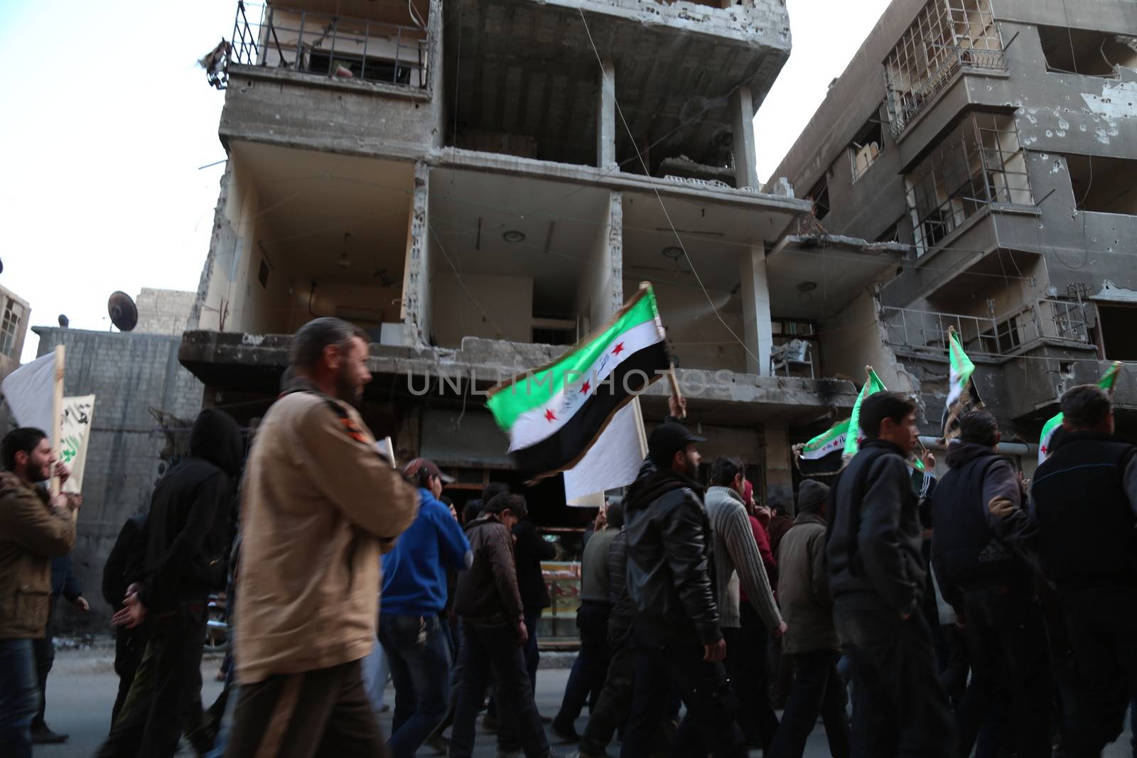 SYRIA, Saqba: Hundreds of Syrians hold a pre-Baath Syrian flag, that was adopted by the Syrian revolution during the uprising, on March 16, 2016 in Saqba, near Damascus, southern Syria, during a protest to mark the fifth anniversary of Syria's revolution. The conflict began with anti-regime protests in mid-March 2011 and spiralled into a bloody war after a harsh government crackdown on demonstrators. 