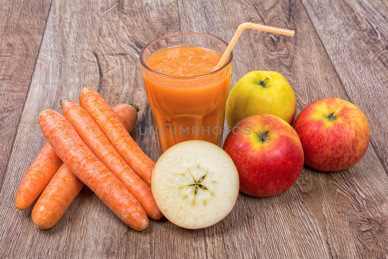 Blended light orange smoothie with ingredients on wooden table