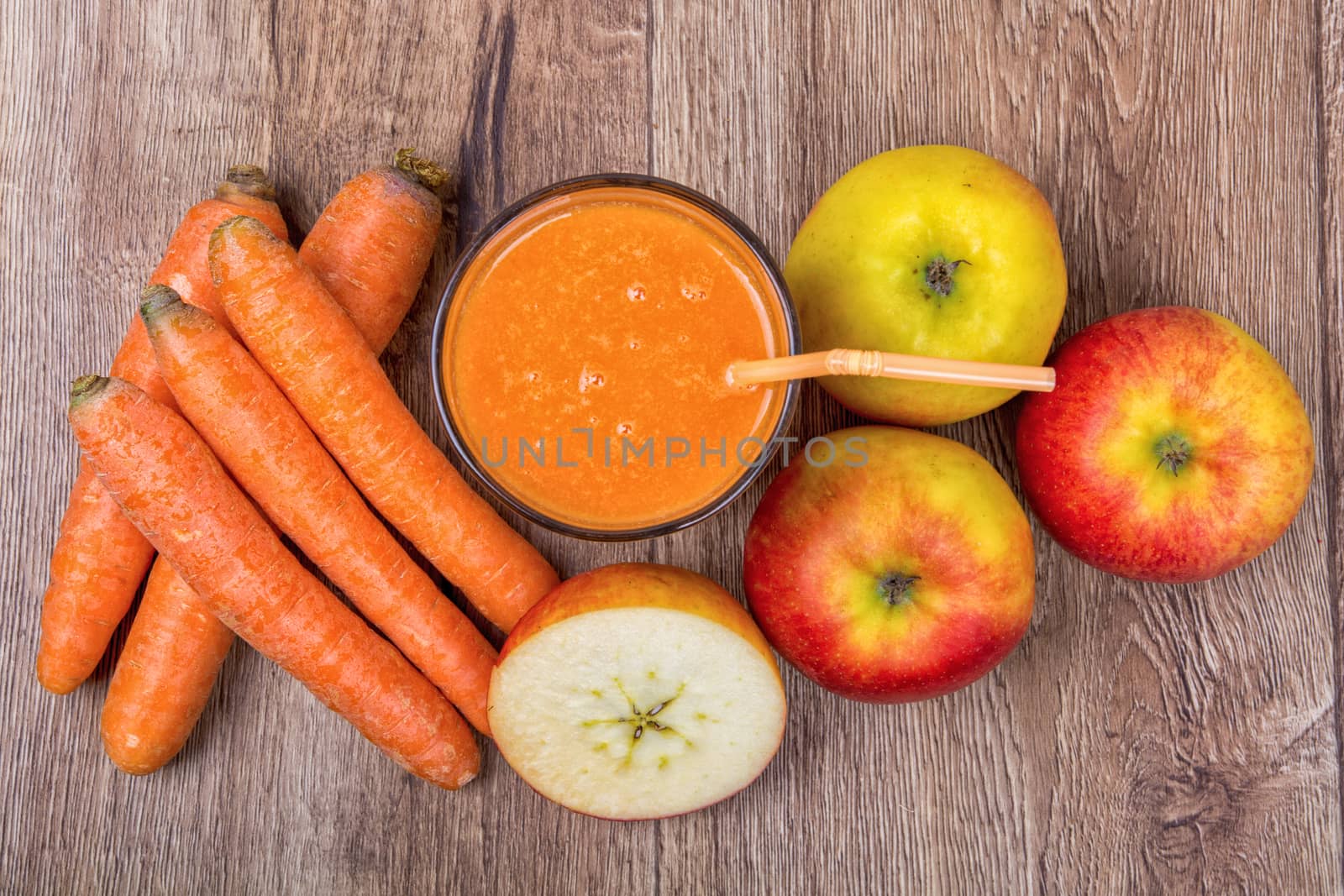 Blended light orange smoothie with ingredients on wooden table