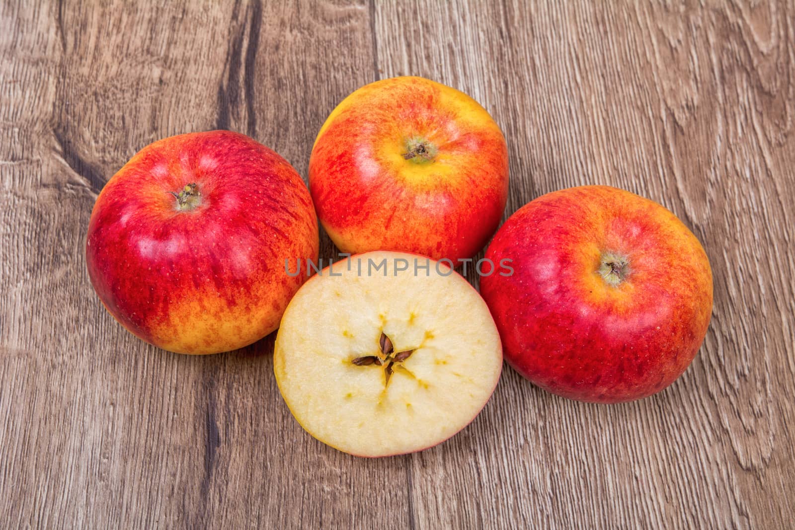 Ripe apples on a brown wooden background