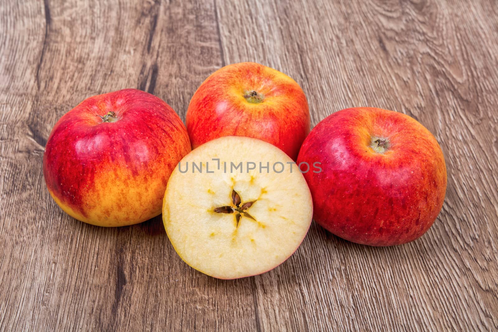 Ripe apples on a brown wooden background