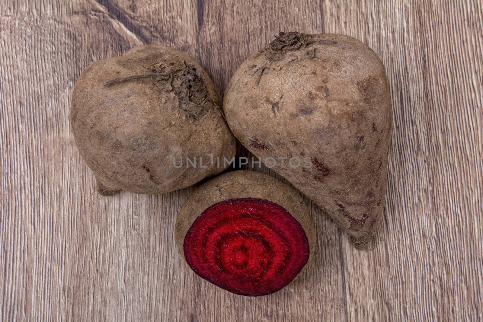 The red beets on a brown wooden background