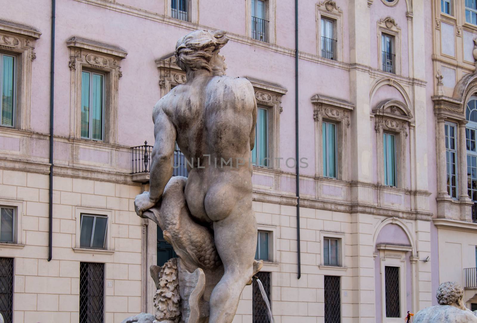 View from the back part on the statue. Windows and facade of a building in the background.