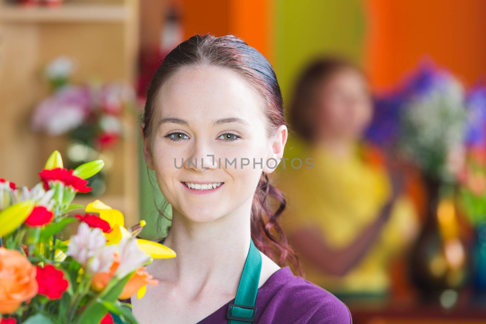 Beautiful young woman in a busy flower shop