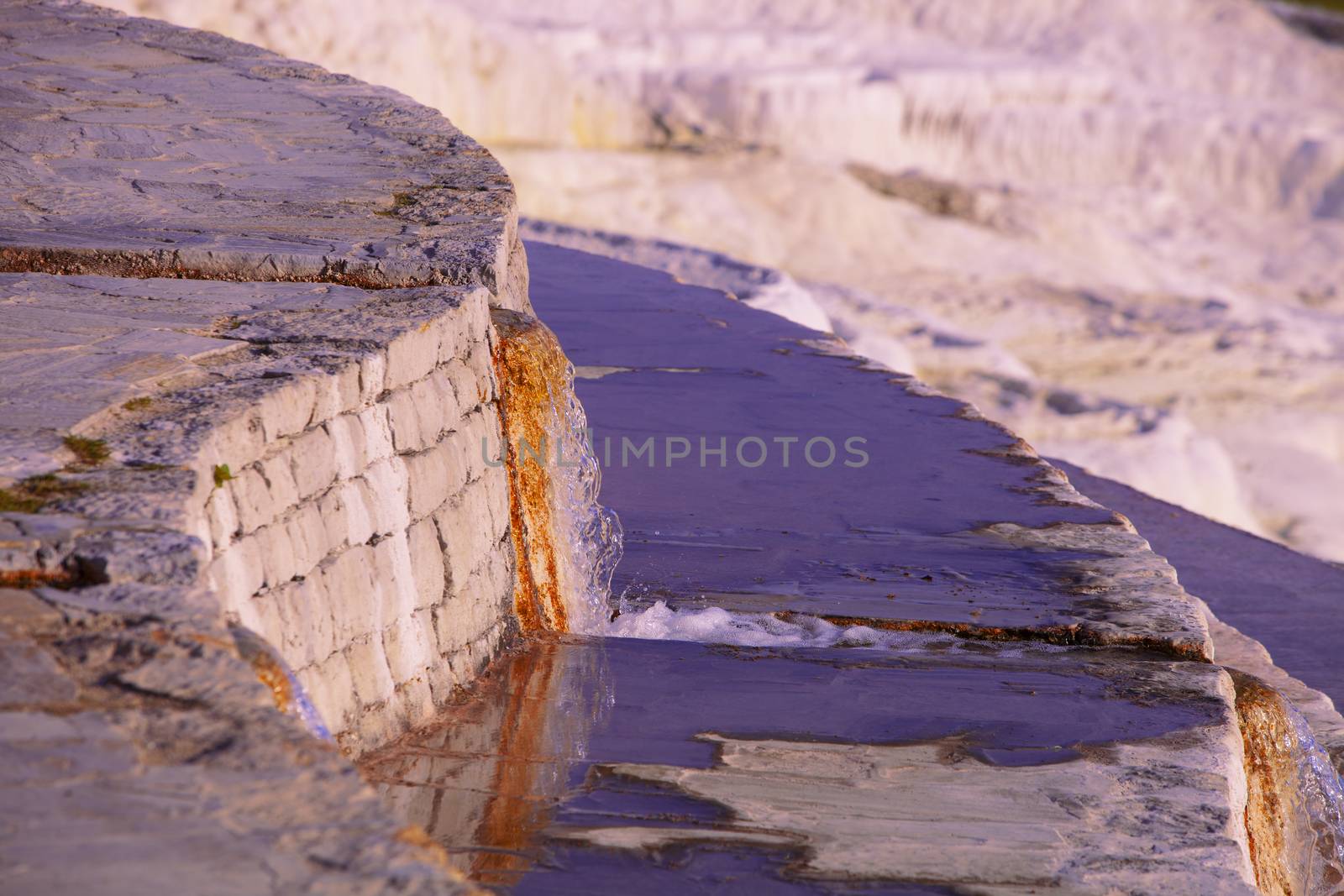 Hot mineral spring water pouring from notch in wall at Pamukkale in Turkey